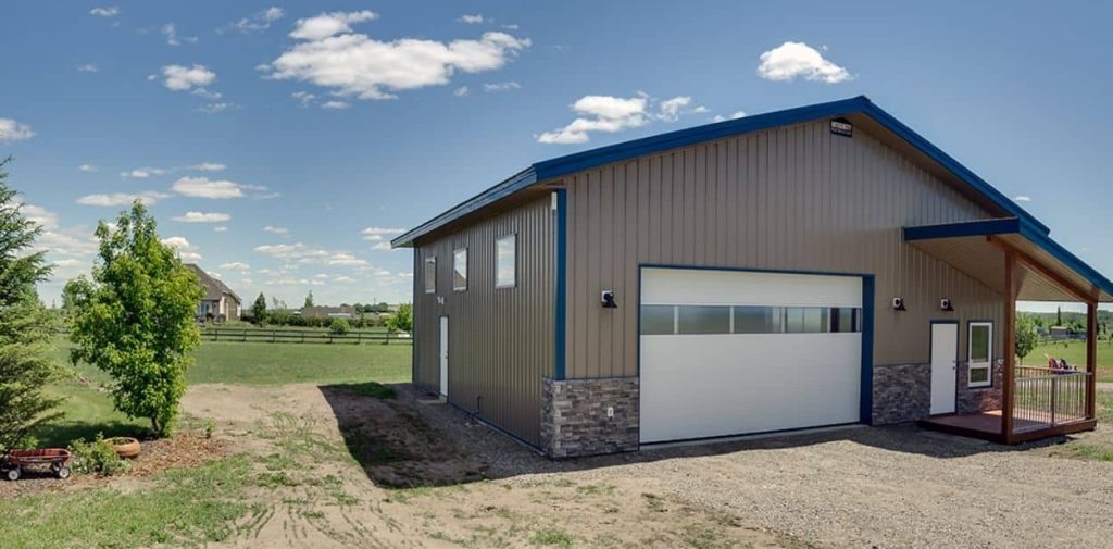 A buckskin lifestyle & Hobby post-frame shop with wainscotting, soffits, and one overhead door