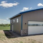 A buckskin lifestyle & Hobby post-frame shop with wainscotting, soffits, and one overhead door