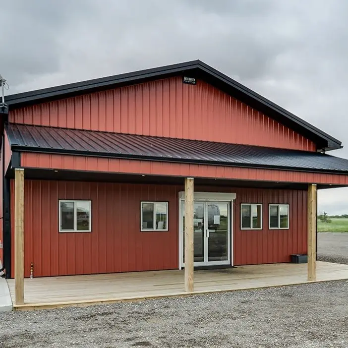 A tile red post-frame commercial build with one overhead door and soffits
