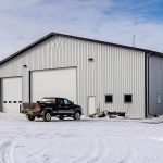 an Iron ore agricultural post-frame shop with three overhead doors and bi-fold door
