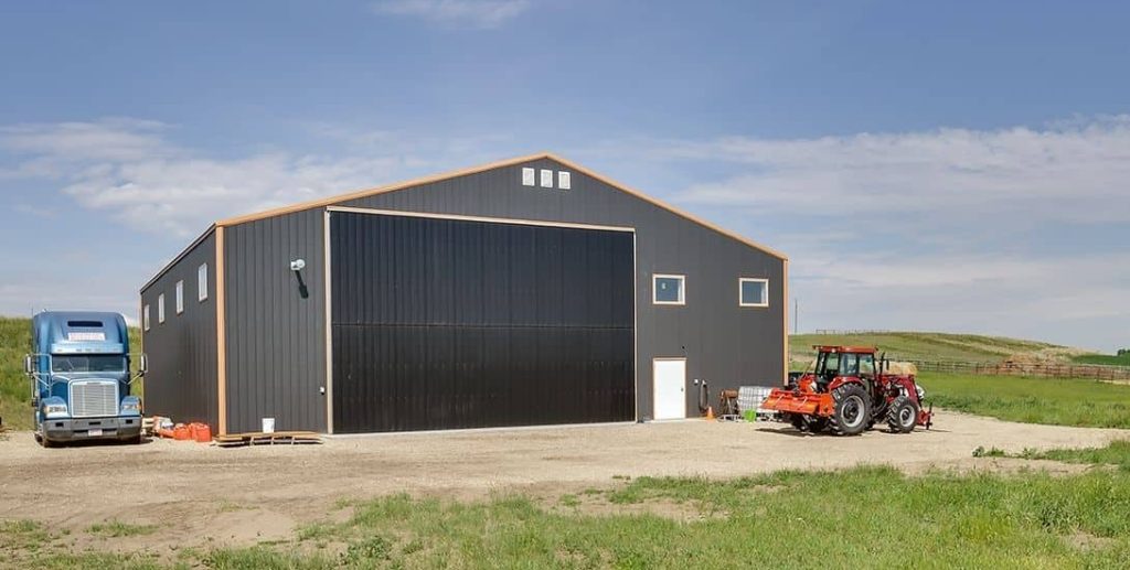 A copper penny agricultural post-frame shop with a bi-fold door