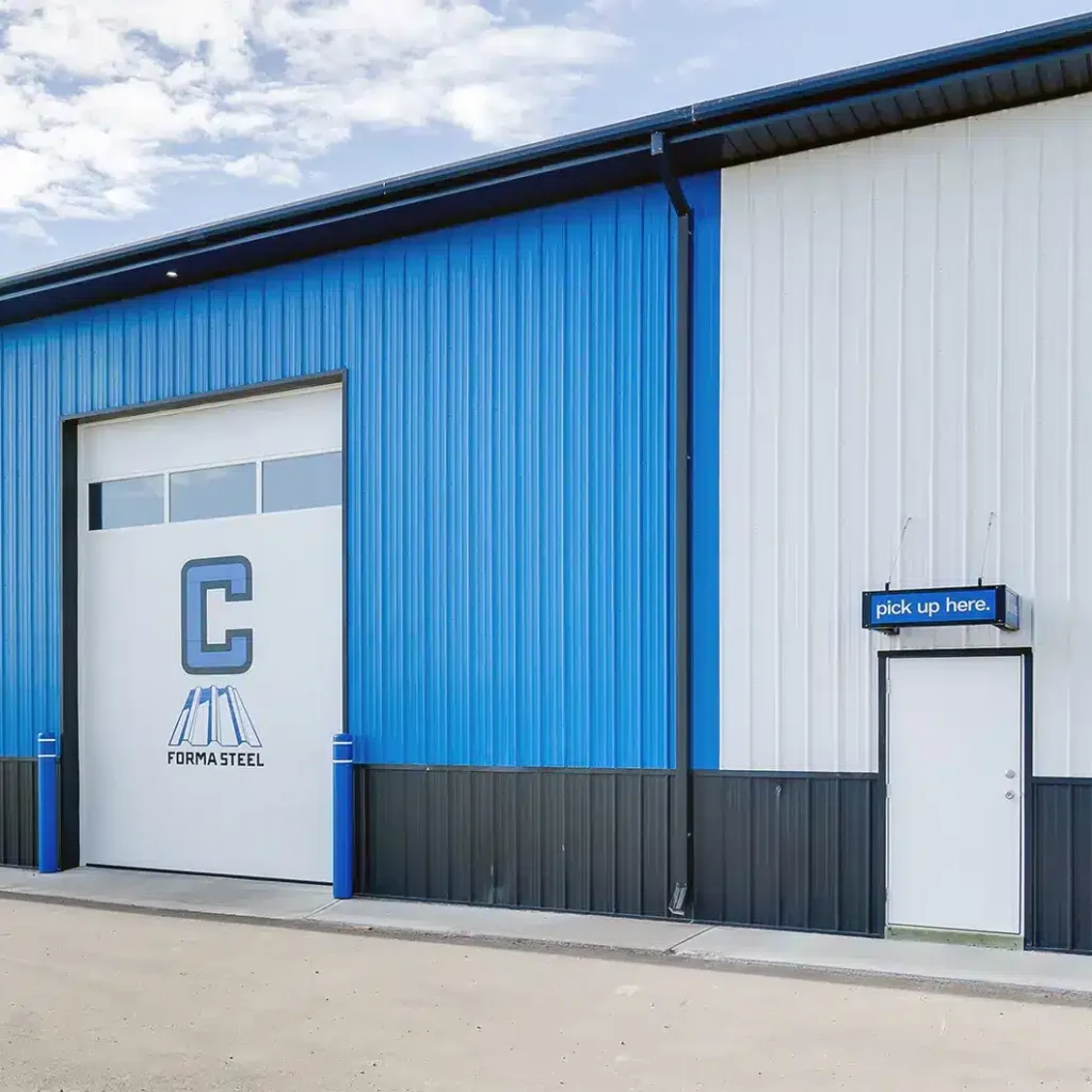A white and blue post-frame commercial build with five overhead doors