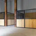 A buckskin post-frame equestrian barn