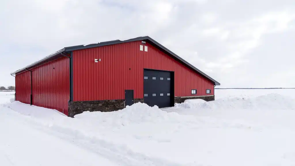 A dark red post-frame agricultural shop