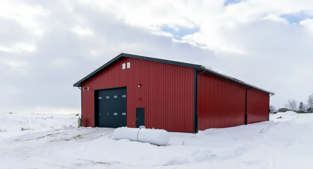 A dark red post-frame agricultural shop