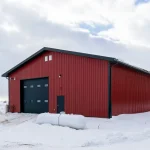 A dark red post-frame agricultural shop