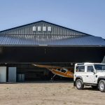 A sable post-frame airplane hangar with a bi-fold door