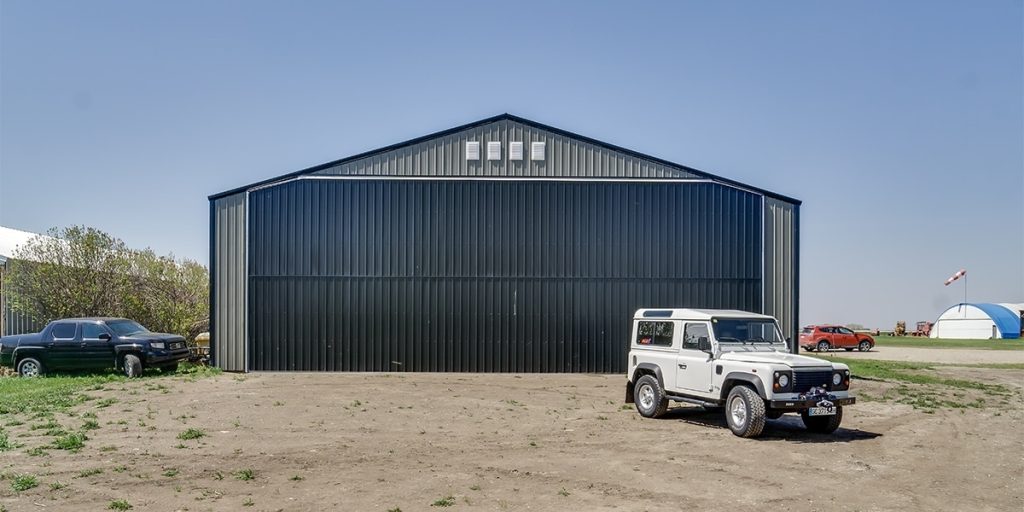 A sable post-frame airplane hangar with a bi-fold door