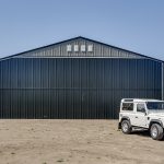 A sable post-frame airplane hangar with a bi-fold door