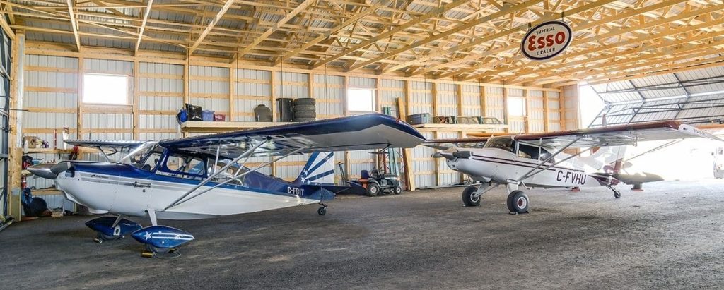 A sable post-frame airplane hangar with a bi-fold door