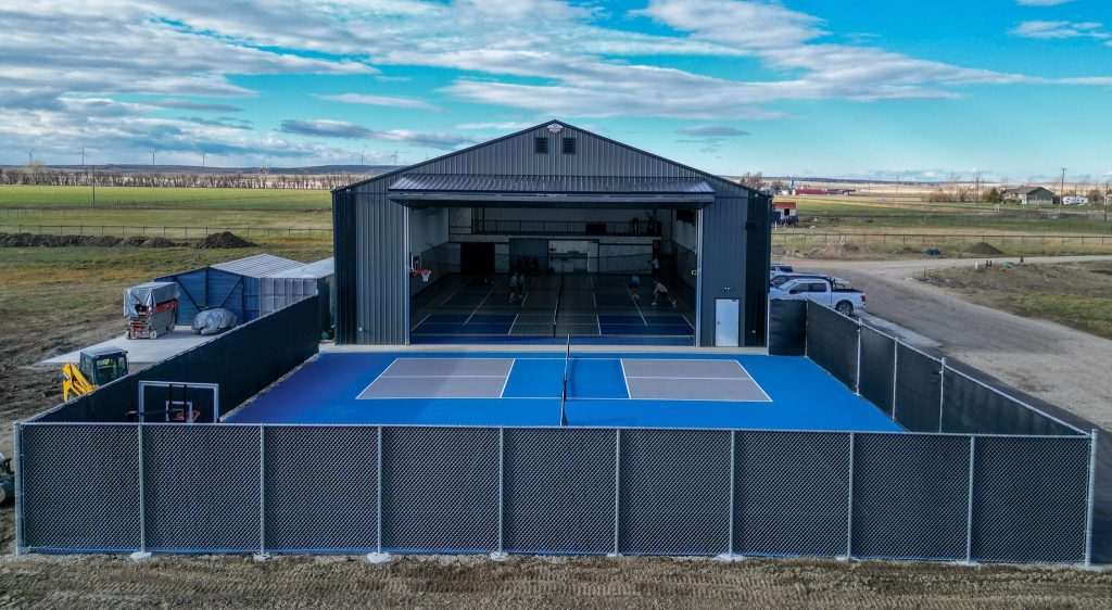 A gunmetal post-frame pickleball hobby shop