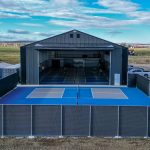 A gunmetal post-frame pickleball hobby shop