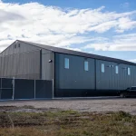 A gunmetal post-frame pickleball hobby shop