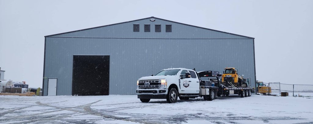 A regent grey post-frame airplane hangar with a bi-fold door