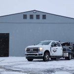 A regent grey post-frame airplane hangar with a bi-fold door