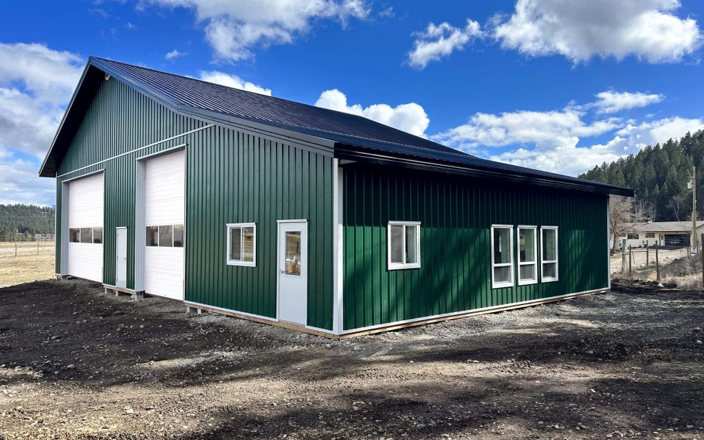A melchers green lifestyle & Hobby post-frame shop with two overhead doors and soffits