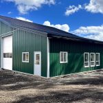 A melchers green lifestyle & Hobby post-frame shop with two overhead doors and soffits