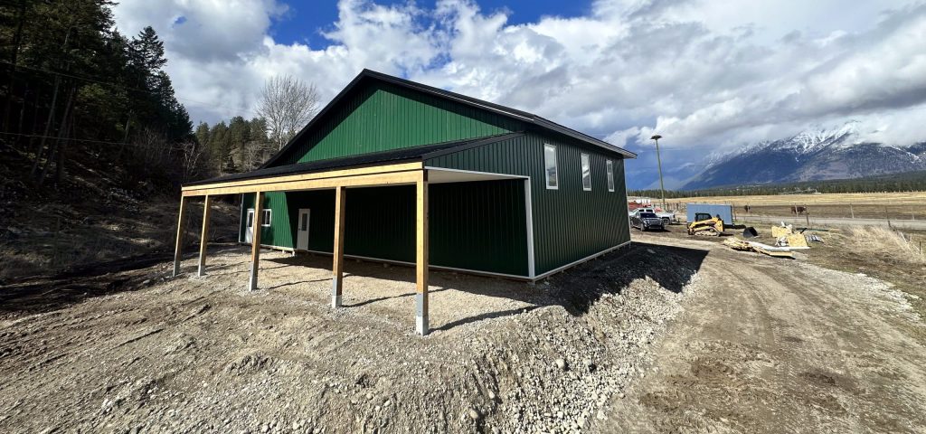 A melchers green lifestyle & Hobby post-frame shop with two overhead doors and soffits