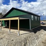A melchers green lifestyle & Hobby post-frame shop with two overhead doors and soffits