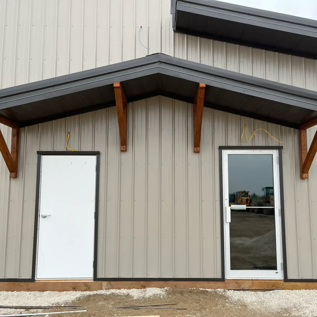 A hickory post-frame airplane hangar with 5 overhead doors and a bi-fold door