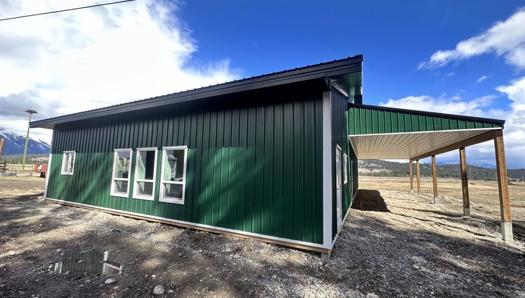 A melchers green lifestyle & Hobby post-frame shop with two overhead doors and soffits