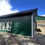 A melchers green lifestyle & Hobby post-frame shop with two overhead doors and soffits