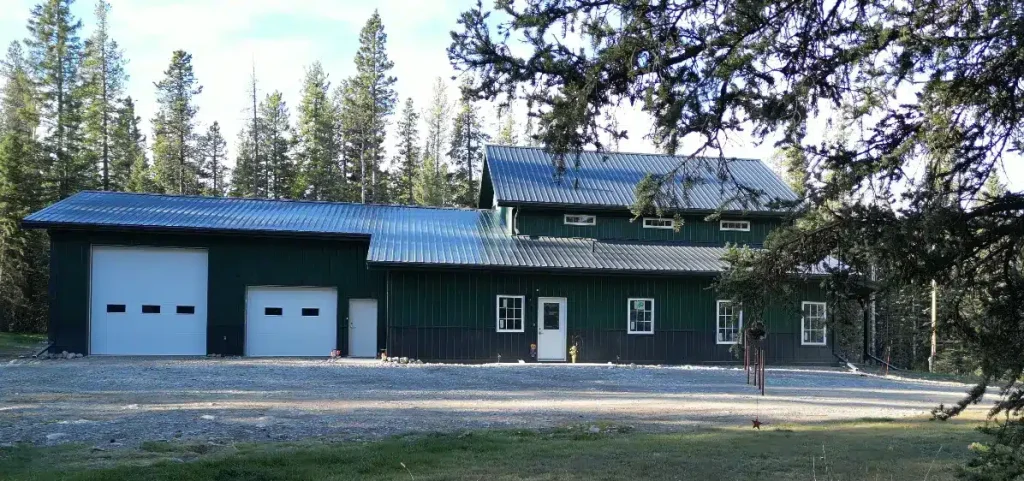 A post-frame melchers green residential barndominium with an attached garage