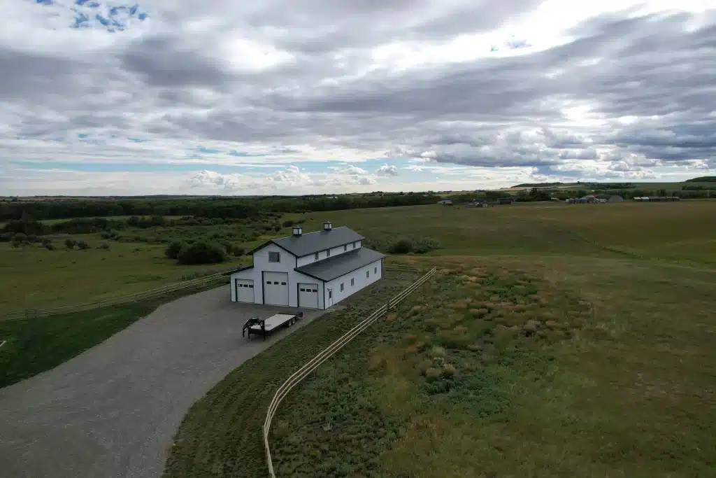 A bright white post-frame equestrian barn