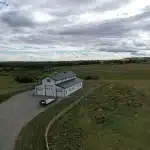 A bright white post-frame equestrian barn