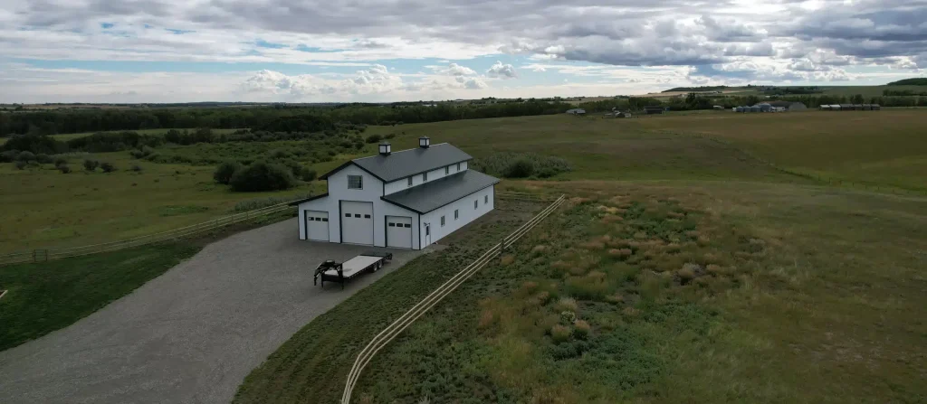A bright white post-frame equestrian barn
