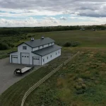 A bright white post-frame equestrian barn