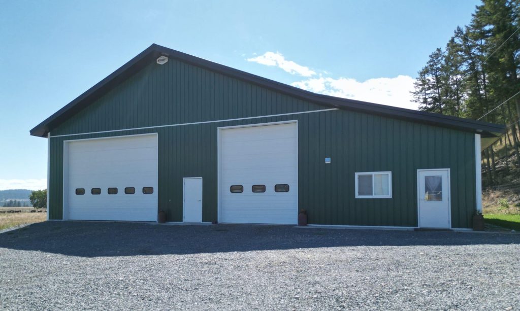 A melchers green lifestyle & Hobby post-frame shop with two overhead doors and soffits