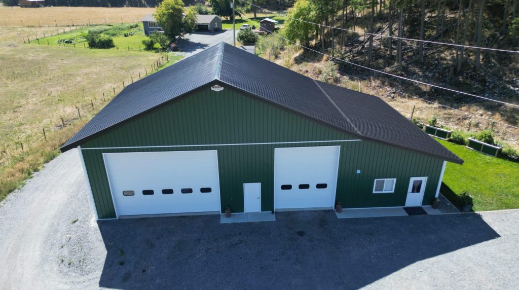 A melchers green lifestyle & Hobby post-frame shop with two overhead doors and soffits