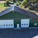 A melchers green lifestyle & Hobby post-frame shop with two overhead doors and soffits