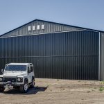 A sable post-frame airplane hangar with a bi-fold door