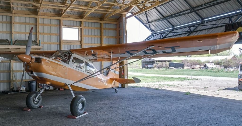 A sable post-frame airplane hangar with a bi-fold door