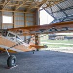 A sable post-frame airplane hangar with a bi-fold door