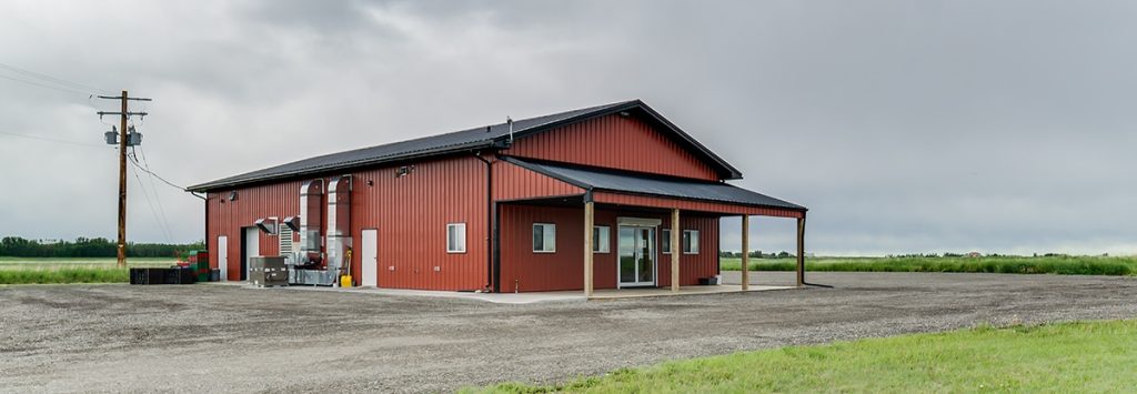A tile red post-frame commercial build with one overhead door and soffits