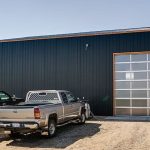 A copper penny agricultural post-frame shop with a bi-fold door