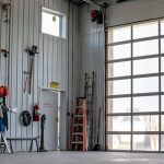 A copper penny agricultural post-frame shop with a bi-fold door