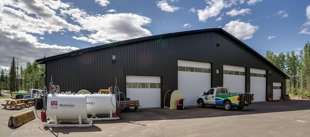 An iron ore post-frame commercial build with ten overhead doors