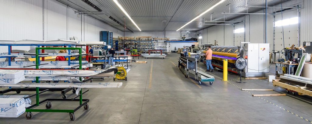 A white and blue post-frame commercial build with five overhead doors