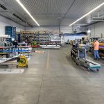 A white and blue post-frame commercial build with five overhead doors