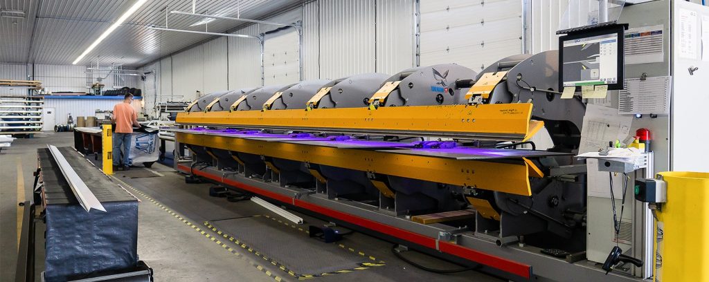 A white and blue post-frame commercial build with five overhead doors