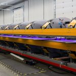 A white and blue post-frame commercial build with five overhead doors