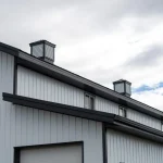 A bright white post-frame equestrian barn