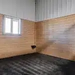 A turquoise post-frame equestrian barn