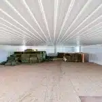 A turquoise post-frame equestrian barn