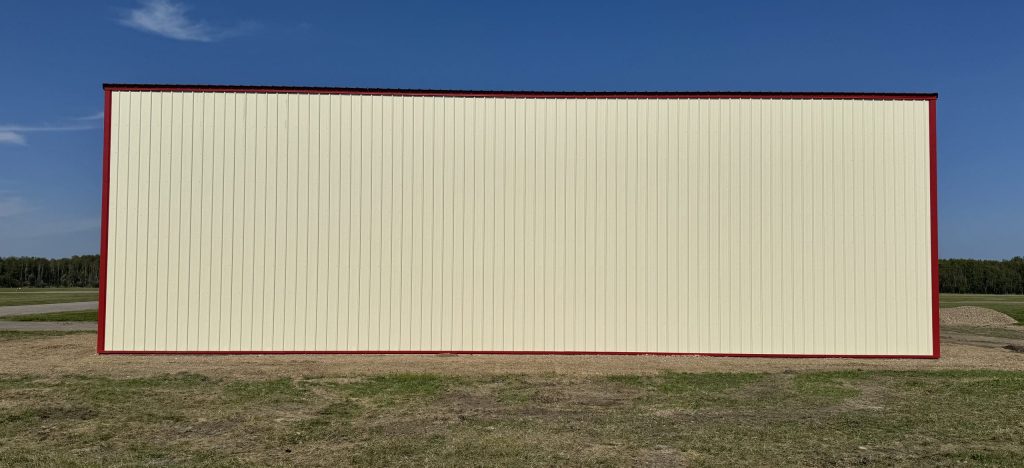 An antique linen post-frame airplane hangar with an overhead and bi-fold door