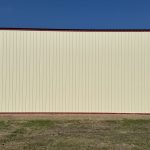 An antique linen post-frame airplane hangar with an overhead and bi-fold door